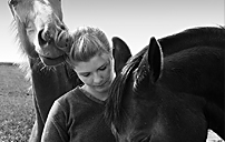 Ung kvinna tillsammans med hästar